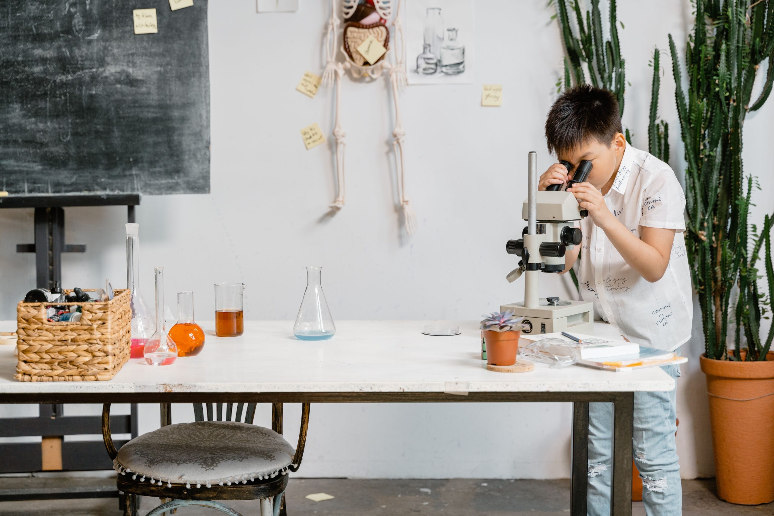 A young boy in a laboratory examining samples through a microscope for educational purposes.